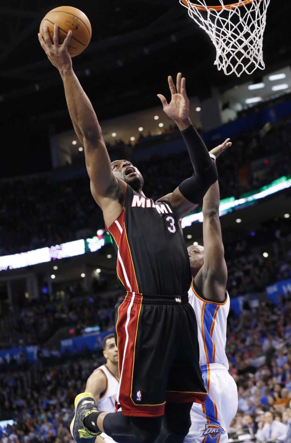 Miami Heat guard Dwyane Wade (3) shoots in front of Oklahoma City Thunder guard Reggie Jackson (15) during the first quarter of an NBA basketball game in Oklahoma City, Thursday, Feb. 20, 2014. (AP Photo/Sue Ogrocki)