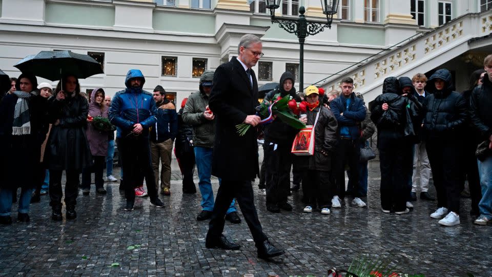 Czech Republic's Prime Minister Petr Fiala walks to lay flowers outside the headquarters of Charles University for victims of mass shooting in Prague on Friday, Dec. 22, 2023. - Denes Erdos/AP