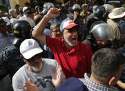 A Lebanese retired soldier, center, shouts slogans as he tries with other protesters to enter the parliament building where lawmakers and ministers are discussing the draft 2019 state budget, in Beirut, Lebanon, Friday, July 19, 2019. The budget is aimed at averting a financial crisis in heavily indebted Lebanon. But it was met with criticism for failing to address structural problems. Instead, the budget mostly cuts public spending and raises taxes. (AP Photo/Hussein Malla)