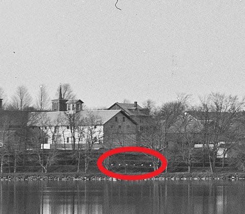 A 19th-century photo of the Lyman School for Boys in Westborough shows what could be headstones, circled, near the shore of Lake Chauncy.