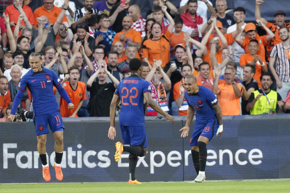 Netherlands' Donyell Malen, right, celebrates after scoring the opening goal during the Nations League semifinal soccer match between the Netherlands and Croatia at De Kuip stadium in Rotterdam, Netherlands, Wednesday, June 14, 2023. (AP Photo/Peter Dejong)