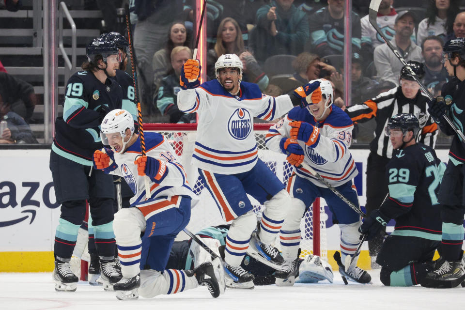 Edmonton Oilers left wing Zach Hyman, front left, reacts after scoring a hat trick, next to Seattle Kraken left wing Jared McCann (19) during the first period of an NHL hockey game Saturday, Nov. 11, 2023, in Seattle. (AP Photo/Jason Redmond)