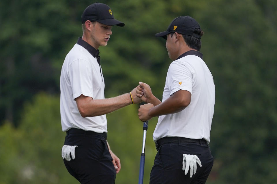 Cam Davis, of Australia, left, and Si Woo Kim, of South Korea, celebrate on the 12th green during their foursomes match at the Presidents Cup golf tournament at the Quail Hollow Club, Thursday, Sept. 22, 2022, in Charlotte, N.C. (AP Photo/Julio Cortez)