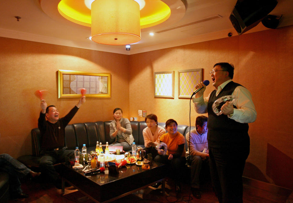 A group of Chinese friends entertain themselves at a Karaoke club (KTV) in Shanghai March 1, 2006. Starting from Wednesday, all entertainment venues throughout China including KTVs, ballrooms, and arcade game halls will shut before 2 am till 8 am, according to the recently issued Regulations on Management of Entertainment Venues. Bars however, are not in the list, according to the official Xinhua News Agency. REUTERS/Nir Elias