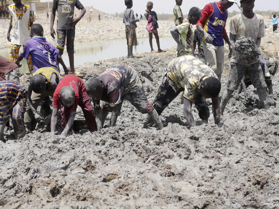 Malians take part in the annual replastering of the world's largest mud-brick building, the Great Mosque of Djenne, Mali, Sunday, May 12, 2024. The building has been on UNESCO's World Heritage in Danger list since 2016. The mosque and surrounding town are threatened by conflict. Djenne's mosque requires a new layer of mud each year before the start of the rainy season in June. (AP Photo/Moustapha Diallo)