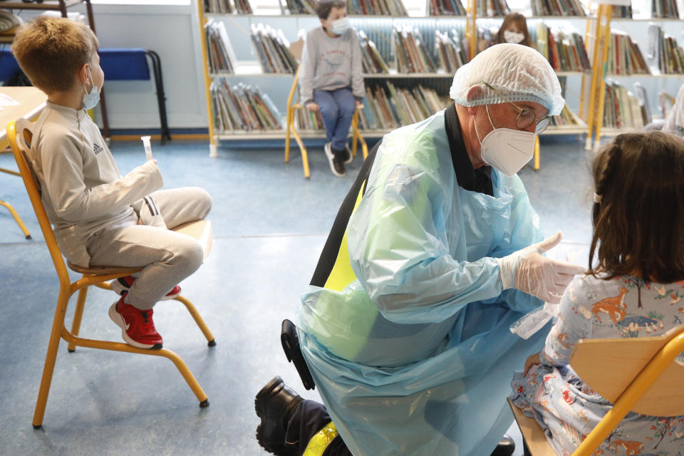 A medical worker checks a tube after a child underwent a saliva COVID-19 test at the Niederau school in Strasbourg, eastern France, Thursday, March 11, 2021. France is rolling out coronavirus tests for young schoolchildren that use saliva samples rather than eye-watering nasal swabs, hoping that they will help prevent school closures as the country's epidemic steadily worsens again. (AP Photo/Jean-Francois Badias)