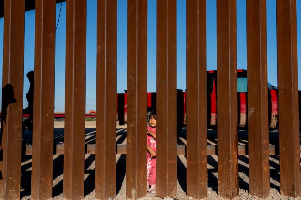 Migrants and asylum seekers from Peru wait for Border Patrol agents to pick them up after crossing the U.S.-Mexico border in San Luis, Ariz., on May 12, 2023.