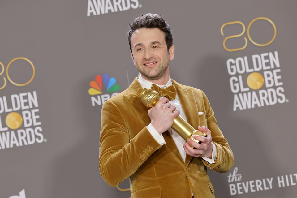 Justin Hurwitz cradles his Golden Globe for best original score, for the movie "Babylon," in the press room during the 80thn annual Golden Globe Awards Tuesday night.