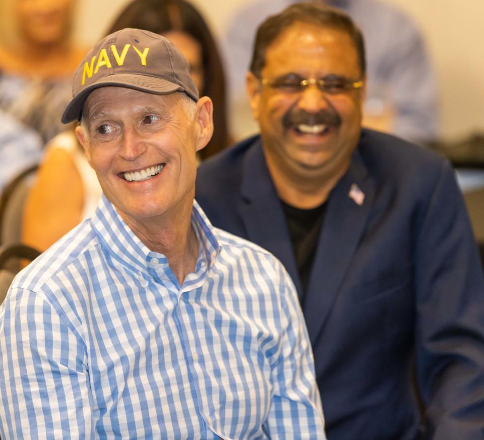U.S. Sen. Rick Scott, left, was all smiles Thursday as local leaders were introduced to him. Local businessman Danny Gaekwad is shown to the right.