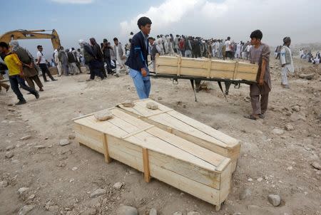 Afghan men carry empty coffins for the victims of yesterday's suicide attack in Kabul, Afghanistan July 24, 2016. REUTERS/ Omar Sobhani