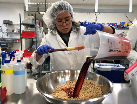 Impossible Foods research technician Alexia Yue pours a heme solution, the key ingredient, into a plant-based mixture for burgers at their facility in Redwood City, California, U.S. March 26, 2019. Picture taken March 26, 2019. REUTERS/Jane Lanhee Lee