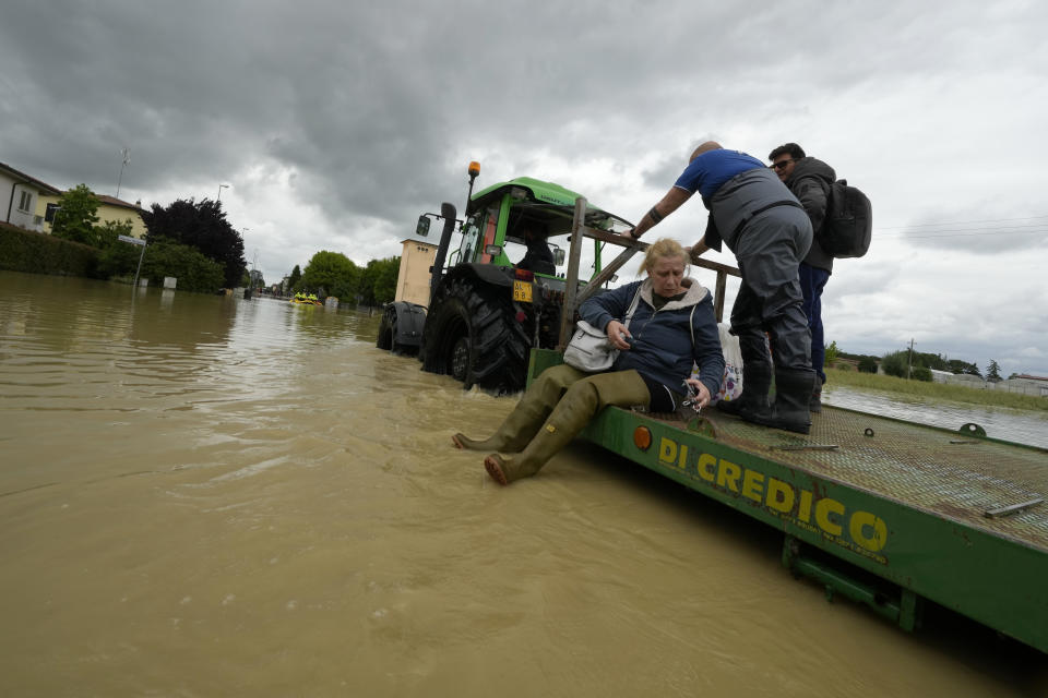 A woman is rescued in Lugo, Italy, Thursday, May 18, 2023. Exceptional rains Wednesday in a drought-struck region of northern Italy swelled rivers over their banks, killing at least eight people, forcing the evacuation of thousands and prompting officials to warn that Italy needs a national plan to combat climate change-induced flooding. (AP Photo/Luca Bruno)