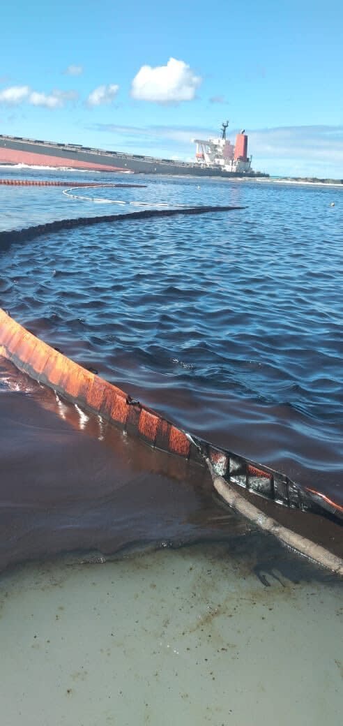 This photo taken and provided by Georges de La Tremoille of Mu Press shows a containment boom collecting oil leaking from the MV Wakashio, a bulk carrier ship that recently ran aground off the southeast coast of Mauritius, Friday, Aug. 7, 2020. The Indian Ocean island of Mauritius declared a “state of environmental emergency” late Friday after a Japanese-owned ship that ran aground offshore days ago began spilling tons of fuel. (Georges de La Tremoille/MU Press via AP)