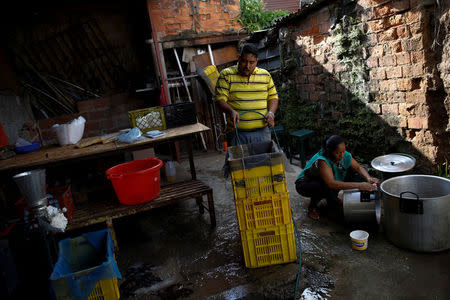 El reparador de equipos médicos, Leandro Colmenares, fabrica masa de maíz en el patio trasero de su casa en Caracas, Venezuela, el 3 de octubre de 2017. REUTERS/Carlos Garcia Rawlins