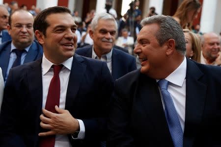 FILE PHOTO: Greek Prime Minister Alexis Tsipras, seen wearing a tie, jokes with Greek Defense Minister Panos Kammenos before his speech at the parliamentary group of Syriza and Independent Greeks in Athens, Greece, June 22, 2018. REUTERS/Costas Baltas/File Photo