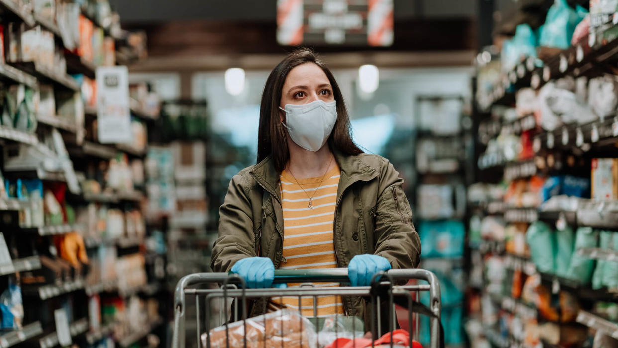 Woman pushing supermarket cart during COVID-19.