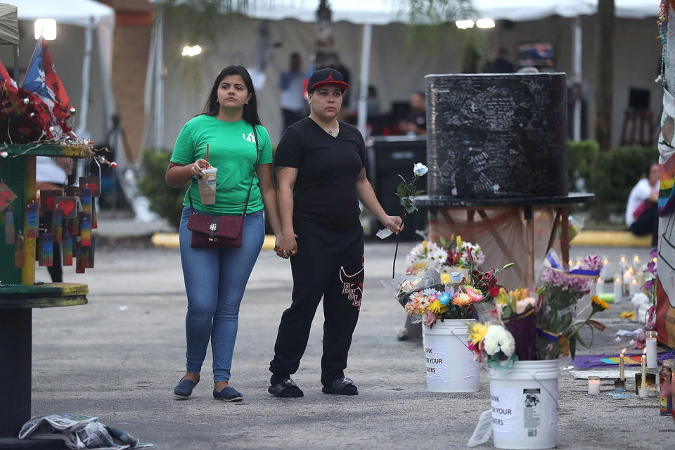 <p>Natascha Soto and Melinda Vargas (L-R) visit the memorial setup outside the Pulse gay nightclub as they remember those lost one year ago during a mass shooting on June 12, 2017 in Orlando, Florida. (Joe Raedle/Getty Images) </p>