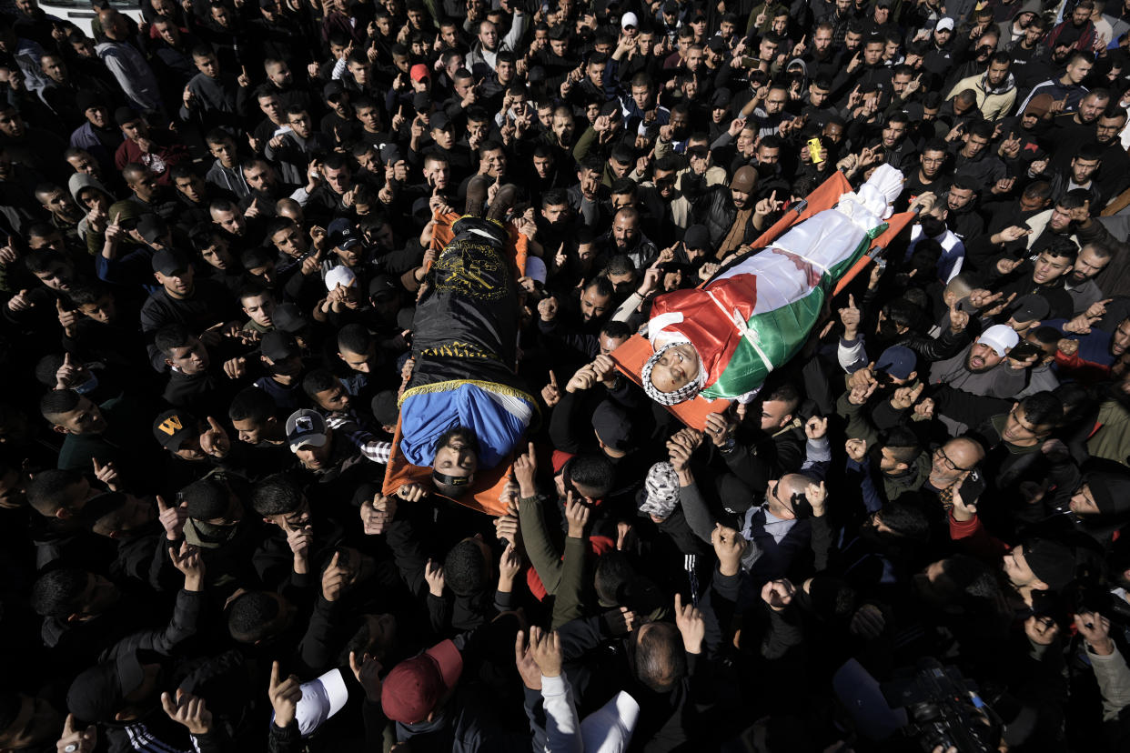 Palestinian mourners carry the bodies of Jawad Bawaqna, 57, a secondary school teacher, right, and Adham Jabareen, 28, during their funeral in the in the West Bank city of Jenin, Thursday, Jan. 19, 2023. Palestinian officials and media reports say Israeli troops shot and killed the Palestinian schoolteacher and a militant during a military raid in the occupied West Bank. (AP Photo/Majdi Mohammed)