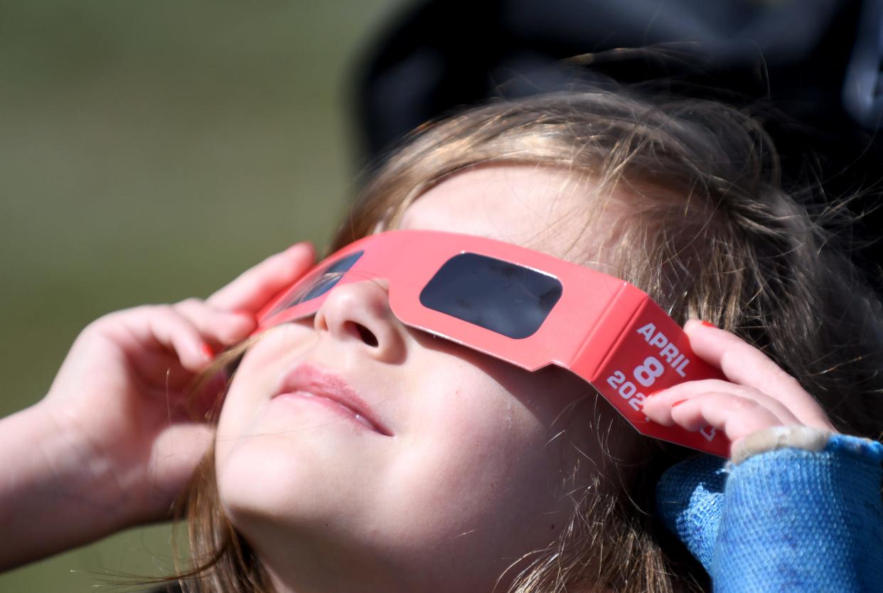 Gracelyn Mallow, 5, of Canal Fulton tries out her solar glasses as she peeks at the sun in St. Helena Park as she prepares for the total solar eclipse. Monday, April 08, 2024.