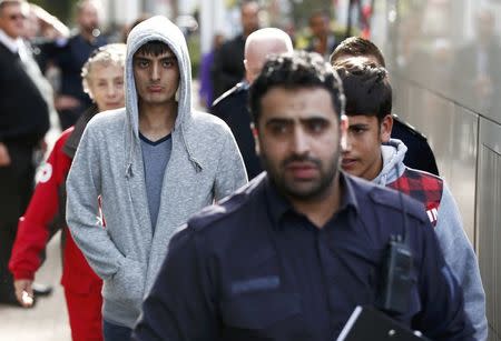 UK Border Force staff escort the first group of unaccompanied minors from the Jungle migrant camp in Calais to be brought to Britain as they arrive at an immigration centre in Croydon, south London, October 17, 2016. REUTERS/Peter Nicholls