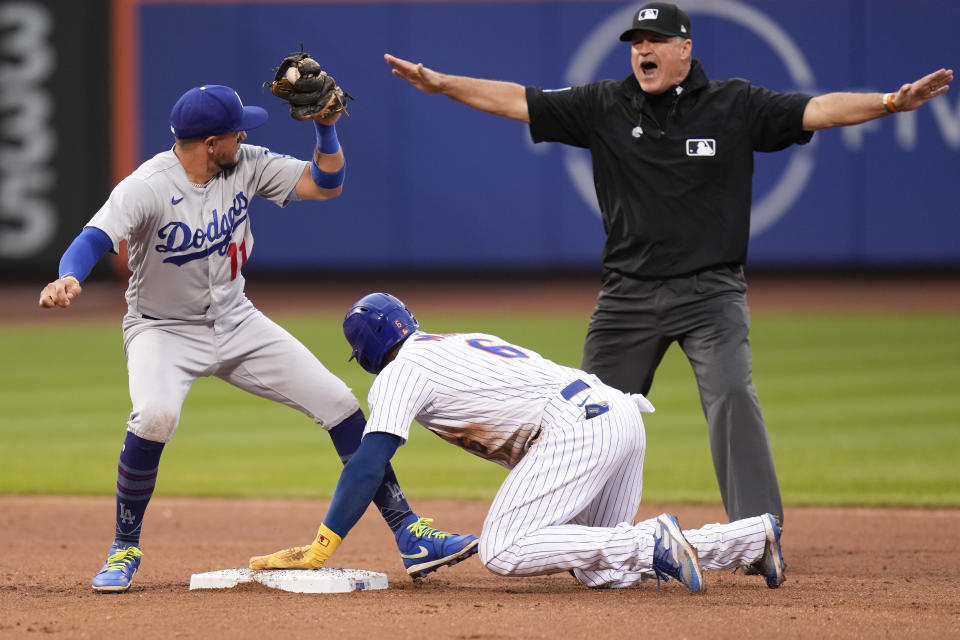 Los Angeles Dodgers shortstop Miguel Rojas, left, looks to umpire Tony Randazzo as New York Mets' Starling Marte steals second base during the fifth inning of the baseball game at Citi Field, Sunday, July 16, 2023, in New York. (AP Photo/Seth Wenig)