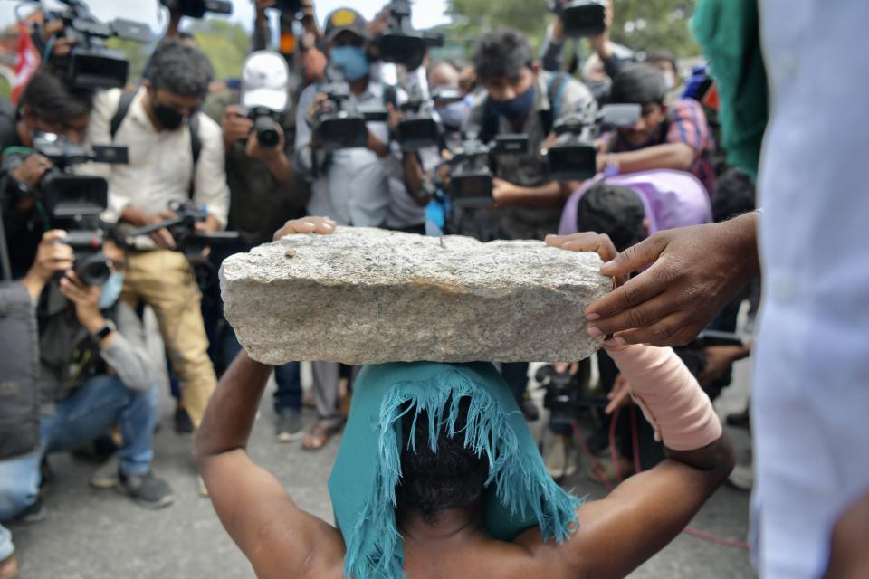 Media personnel document an activist from a farmer right organisation during a protest following the recent passing of agriculture bills in the Lok Sabha (lower house), in Bangalore on September 25, 2020. - Angry farmers took to the streets and blocked roads and railways across India on September 25, intensifying protests over major new farming legislation they say will benefit only big corporates. (Photo by Manjunath Kiran / AFP) (Photo by MANJUNATH KIRAN/AFP via Getty Images)