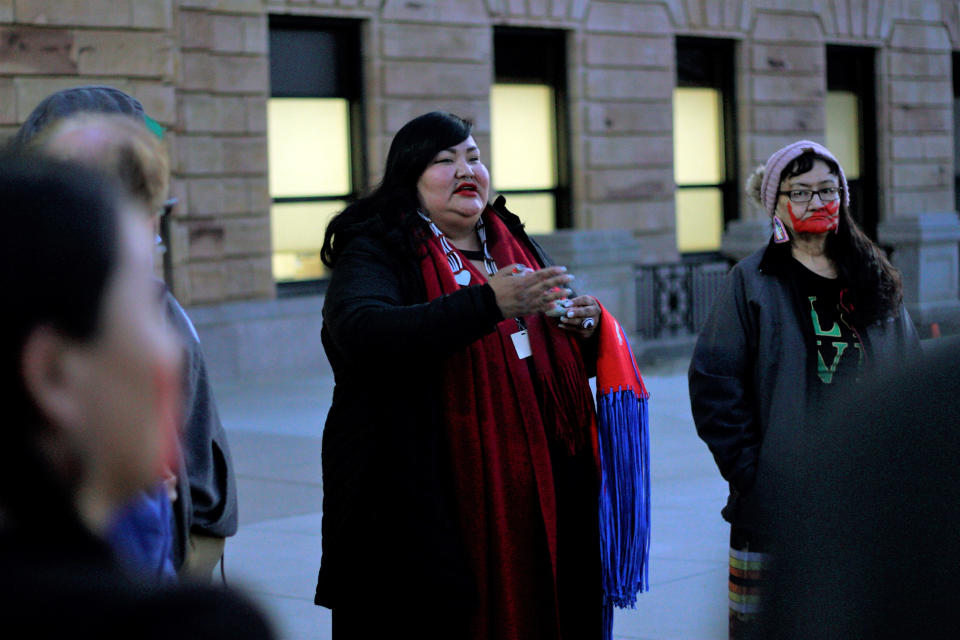 FILE - In this March 3, 2020, photo, Candi Brings Plenty, center, prays outside the Capitol in Pierre, S.D. Major construction projects moving forward along the U.S. borders with Canada and Mexico amid the coronavirus pandemic are raising fears workers could spread infections within nearby communities, including several Native American tribes. Plenty, an indigenous justice organizer with the American Civil Liberties Union, said the organization is trying to figure out creative ways to protest while still following guidelines from the Centers for Disease Control and Prevention. (AP Photo/Stephen Groves, File)