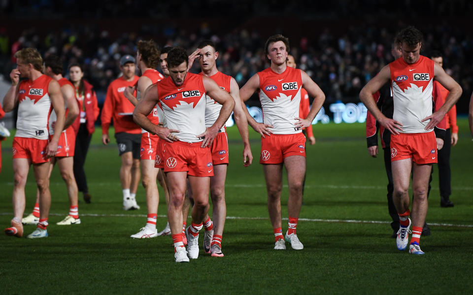 Sydney Swans players leave the ground.