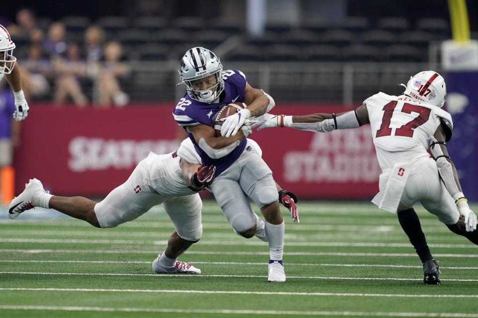 Kansas State running back Deuce Vaughn (22) carries the ball as Stanford linebacker Jordan Fox , rear, and cornerback Kyu Blu Kelly (17) attempt to make a stop in the second half of an NCAA college football game in Arlington, Texas, Saturday, Sept. 4, 2021. (AP Photo/Tony Gutierrez)