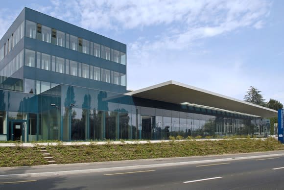 Glass building with Philip Morris logo on it, next to an empty street.