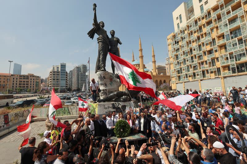 FILE PHOTO: People hold Lebanese flags as newly-elected Lebanese independent lawmakers stand together at Martyrs' Square