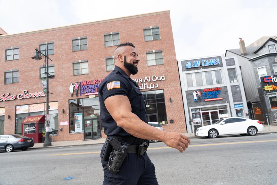 Paterson Police Officer Ramy Amir walks along Main St in south Paterson, NJ on Friday Aug. 4, 2023. He is one of a hand full of Muslim police officers in the Paterson Police Department. 