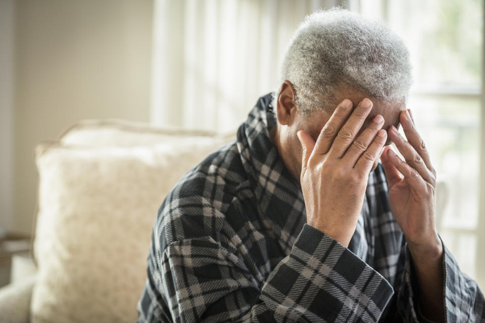 An older man with his face in his hands