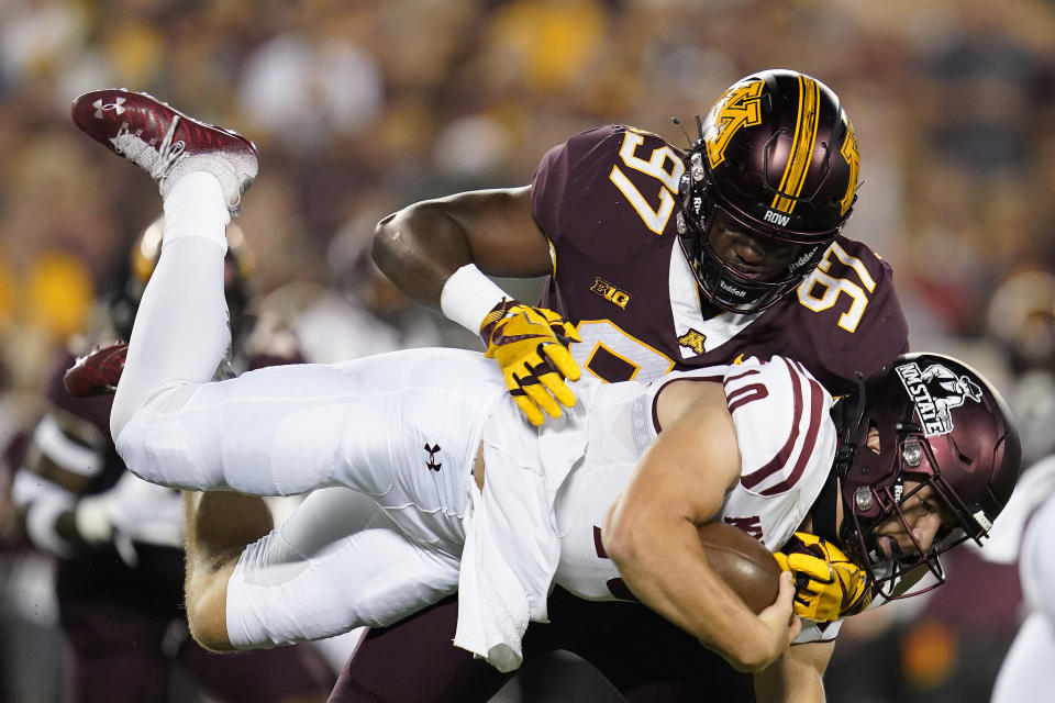 New Mexico State quarterback Diego Pavia, bottom, is tackled by Minnesota defensive lineman Jalen Logan-Redding (97) during the first half of an NCAA college football game Thursday, Sept. 1, 2022, in Minneapolis. (AP Photo/Abbie Parr)