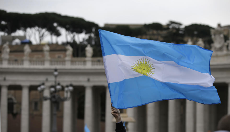 A visitor waves an Argentine flag before the Angelus prayer by Pope Francis in St. Peter's Square at the Vatican, Sunday, March 17, 2013. (AP Photo/Gregorio Borgia)