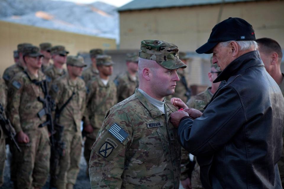 As the sun sets over the rugged snow capped mountains, Vice President Joe Biden pins a Bronze Star on Staff Sergeant Workman at Forward Operating Base Airborne in Wardak Province, Afghanistan. January 11,&nbsp;2011.