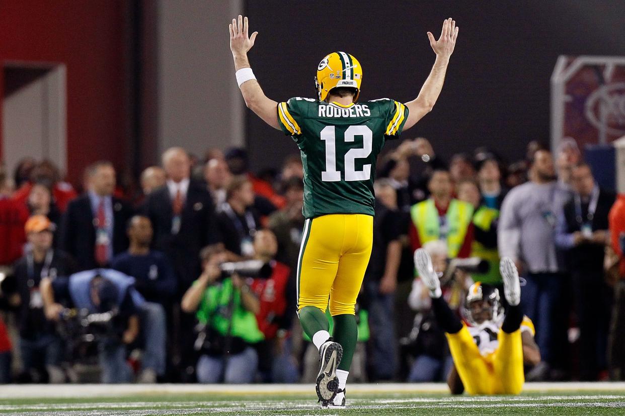 Aaron Rodgers #12 of the Green Bay Packers celebrates after a touchdown pass to Greg Jennings against the Pittsburgh Steelers during Super Bowl XLV at Cowboys Stadium on February 6, 2011 in Arlington, Texas.