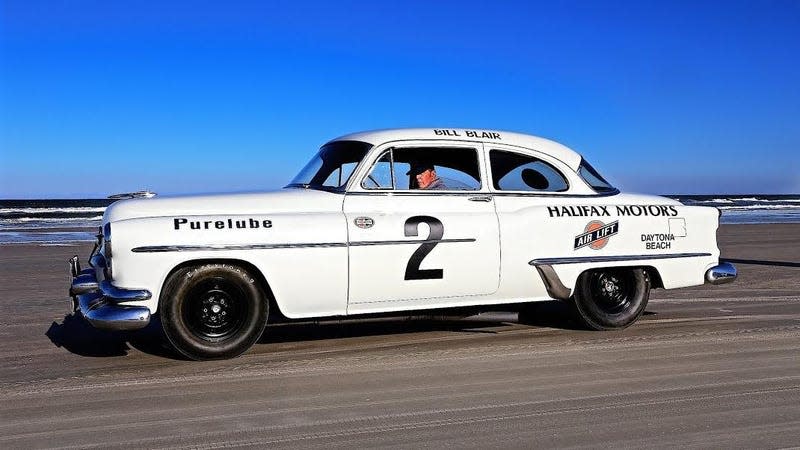Bill Blair Jr. driving a white vintage car