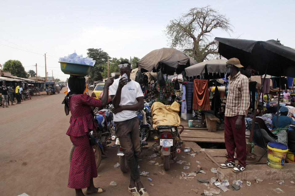 Amadou Coulibaly, a 25-years-old, motorcycle taxi driver, drinks a sachet water to cool off under a blazing sun.in Bamako, Mali, Thursday, April, 18, 2024. Street vendors in Mali's capital of Bamako peddle water sachets, ubiquitous for this part of West Africa during the hottest months of the year. On Thursday, temperatures in Bamako reached 44 degrees Celsius (111 Fahrenheit) and weather forecasts say it's not letting up anytime soon. (AP Photo/Baba Ahmed)