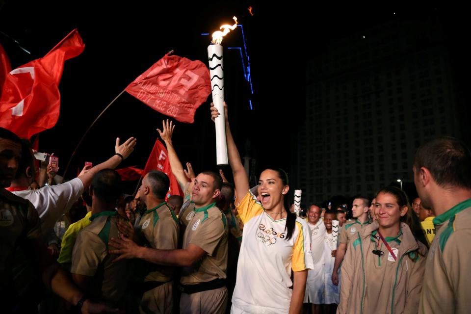 <p>Model Adriana Lima carries the Olympic torch in Maua Square in Rio de Janeiro, Brazil, August 4, 2016. REUTERS/Pilar Olivares TPX IMAGES OF THE DAY </p>