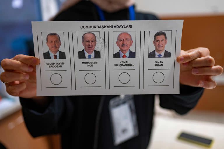 Una persona sostiene papeletas con los candidatos presidenciales turcos en un colegio electoral durante las elecciones presidenciales y parlamentarias de Turquía en Estambul el 14 de mayo de 2023. 