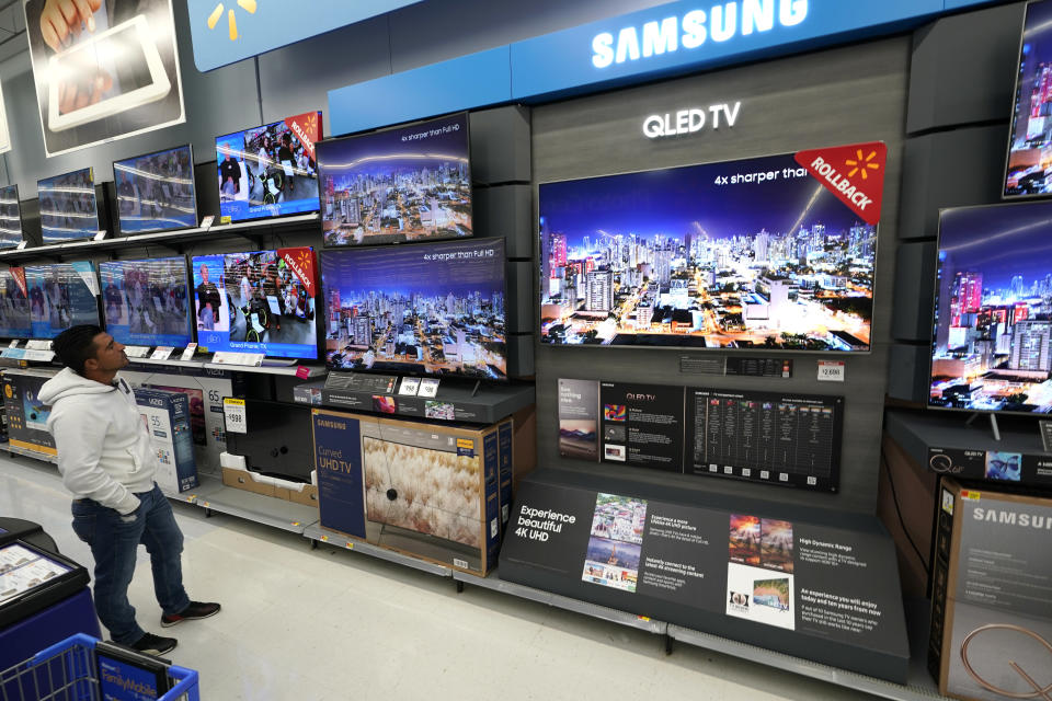 A shopper looks at televisions at a Walmart Supercenter Friday, Nov. 9, 2018, in Houston. (AP Photo/David J. Phillip)