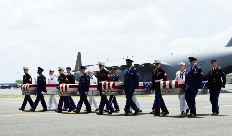 Military members carry transfer cases from a C-17 at a ceremony marking the arrival of the remains believed to be of American service members who fell in the Korean War at Joint Base Pearl Harbor-Hickam in Hawaii, Wednesday, Aug. 1, 2018. North Korea handed over the remains last week. (AP Photo/Susan Walsh)