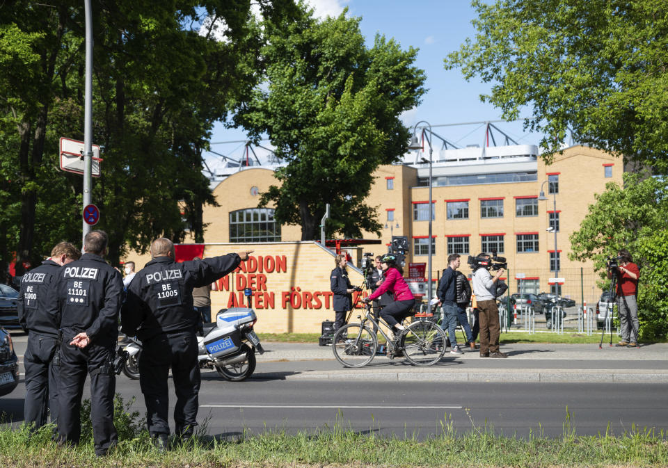 Policemen are standing outside the stadium at the old forest ranger station in Berlin, Germany, Sunday, May 17, 2020, ahead of the German Bundesliga soccer match between Union Berlin and Bayern Munich. (Christophe Gateau/dpa via AP)