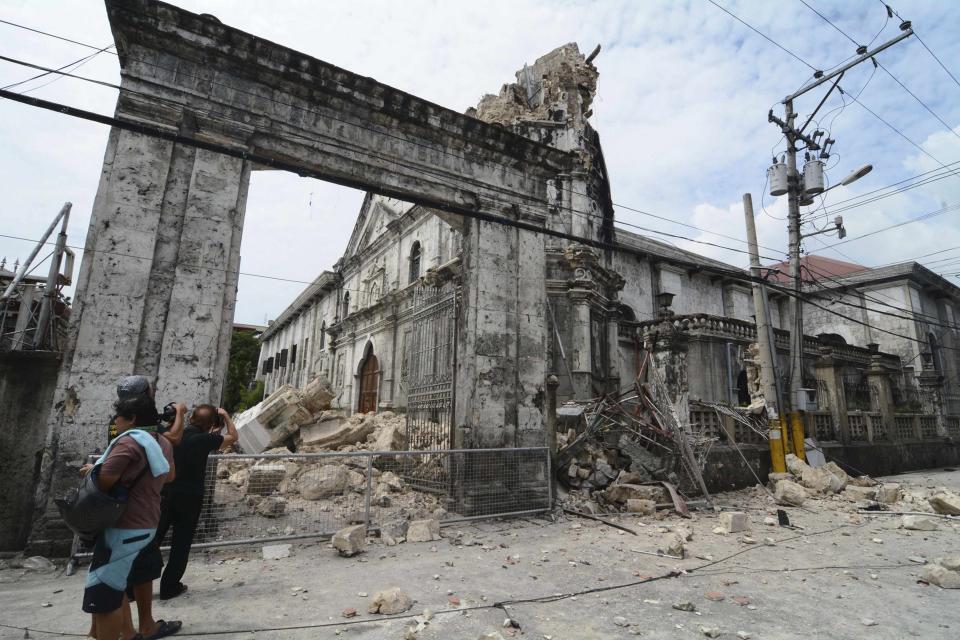 Local photographers takes pictures of the damage to the historic Basilica Minore of Santo Nino de Cebu after an earthquake hit the church in Cebu City, central Philippines October 15, 2013. At least six people were killed when buildings collapsed on islands popular with tourists in the central Philippines on Tuesday, radio reports said, after an earthquake measuring 7.2 hit the region. REUTERS/STRINGER (PHILIPPINES - Tags: DISASTER)