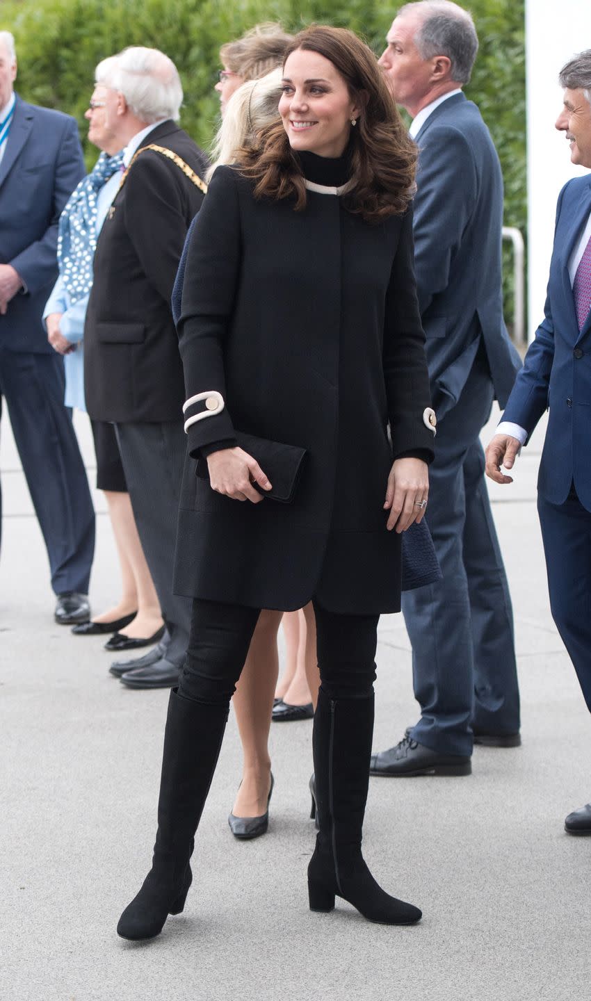 <p>Middleton wears a black and white coat by Goat Fashion, skinny jeans, a black clutch, and knee-high boots during a visit to Birmingham, England. </p>