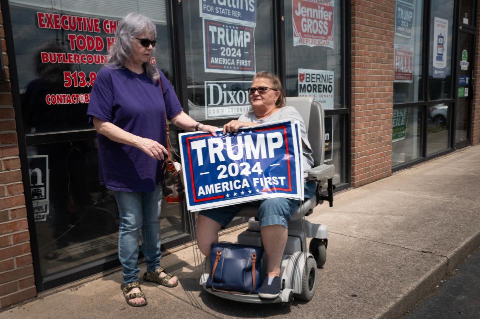 Women leave the headquarters of the Butler County Republican Party carrying campaign yard signs supporting Republican presidential candidate former president Donald Trump on 23 July 2024 in Middletown, Ohio (Getty Images)