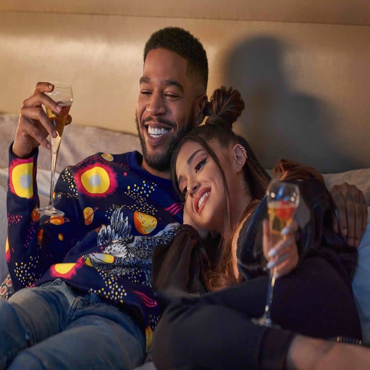 Ariana and Kid Cudi cuddling on the couch