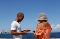 Jason Sanchez makes a transaction with cryptocurrency using the startup Fusyona at the seafront Malecon in Havana