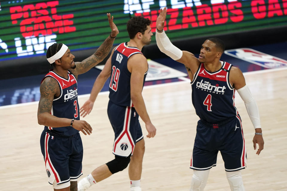 Washington Wizards guard Bradley Beal, left, high-fives teammate Russell Westbrook after Beal was fouled in the first half of an NBA basketball game, Monday, April 19, 2021, in Washington. (AP Photo/Patrick Semansky)